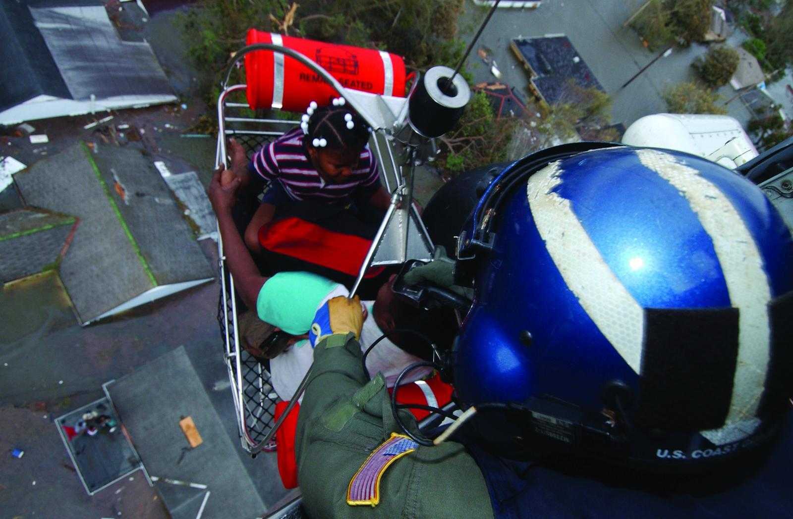 A person is lifted to safety by a Coast Guard helicopter in the aftermath of Hurricane Katrina