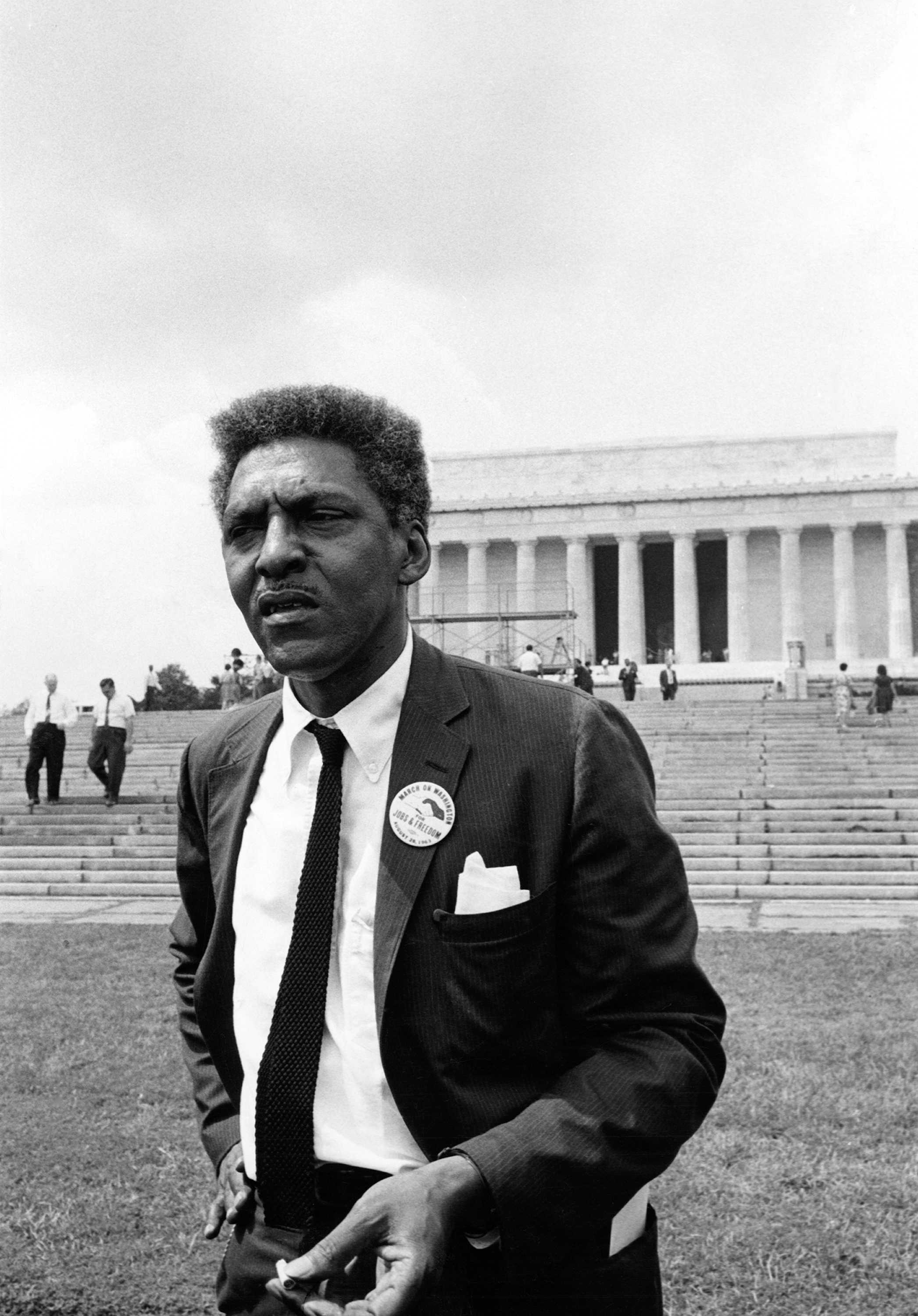Black and white Bayard Rustin on the National Mall during the March on Washington for Jobs and Freedom in front of Lincoln Memorial