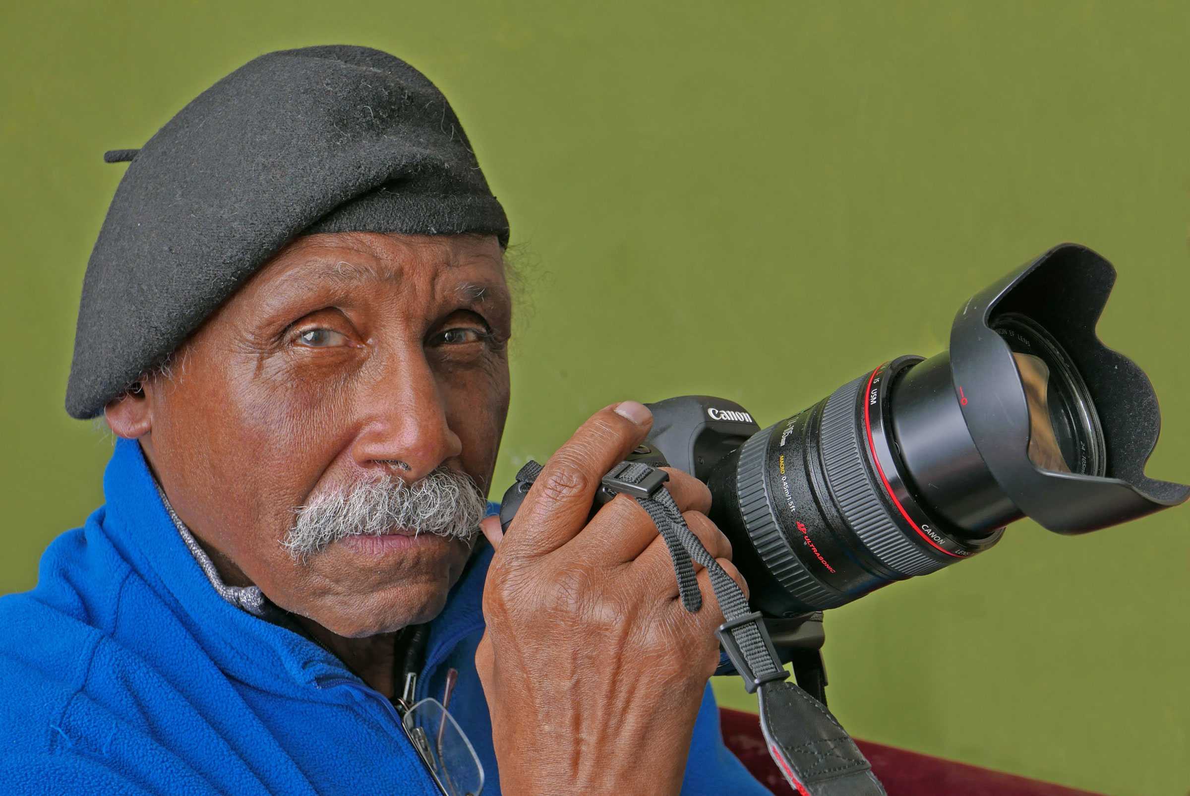 A person in a beret holding a camera.