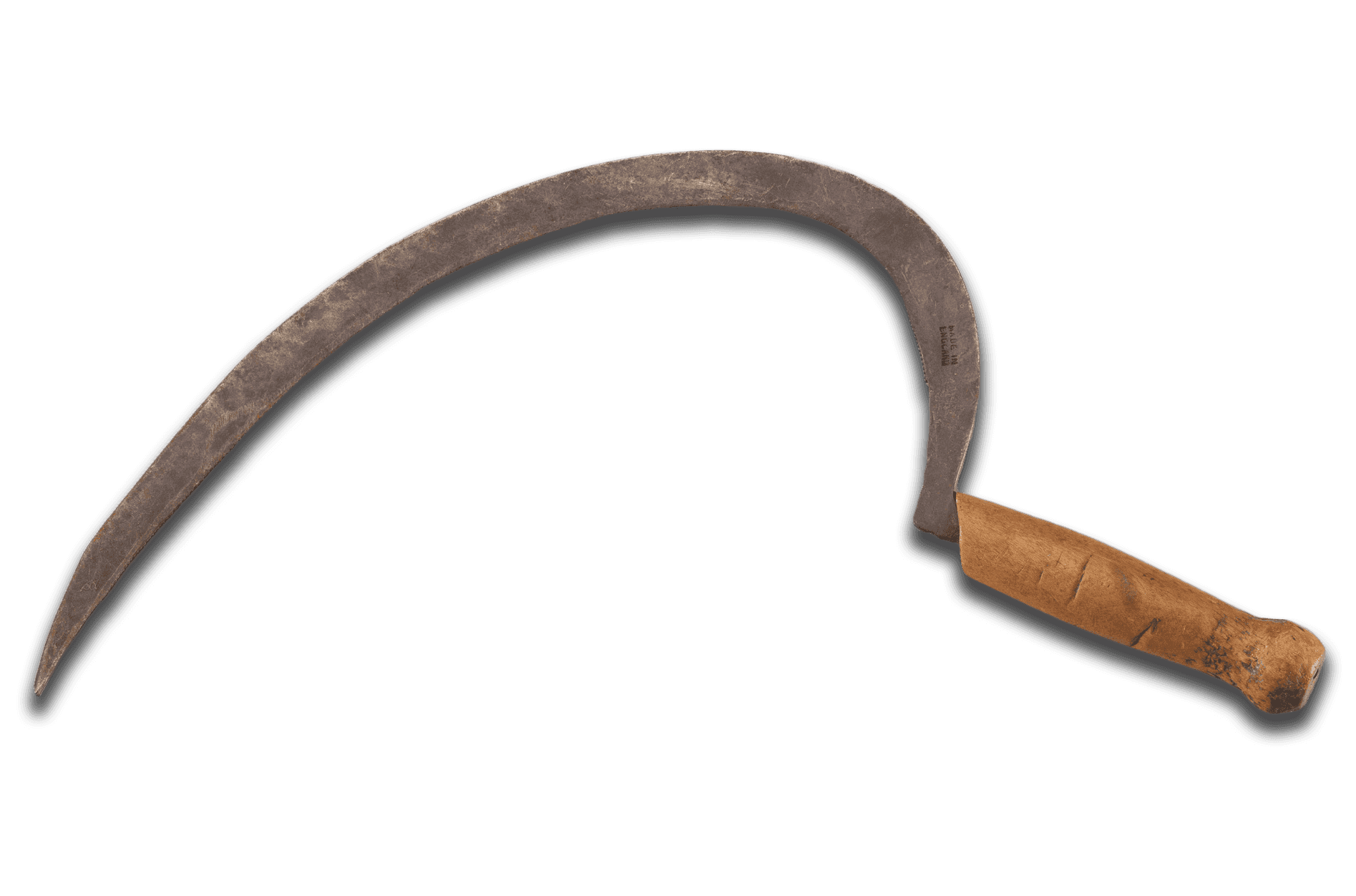 A rice sickle with a wooden handle. The sickle has a short, wooden handle with a curved grip and a rounded base. Carved on the side of the handle are the letters [W Y]. The blade is J-shaped with a serrated interior edge. Stamped on the blade near the handle is a mark that reads [MADE IN / ENGLAND]. The blade's tang protrudes from the bottom of the handle. Attached to the blade is a white paper tag with handwritten, black ink text that reads [SICKLE].