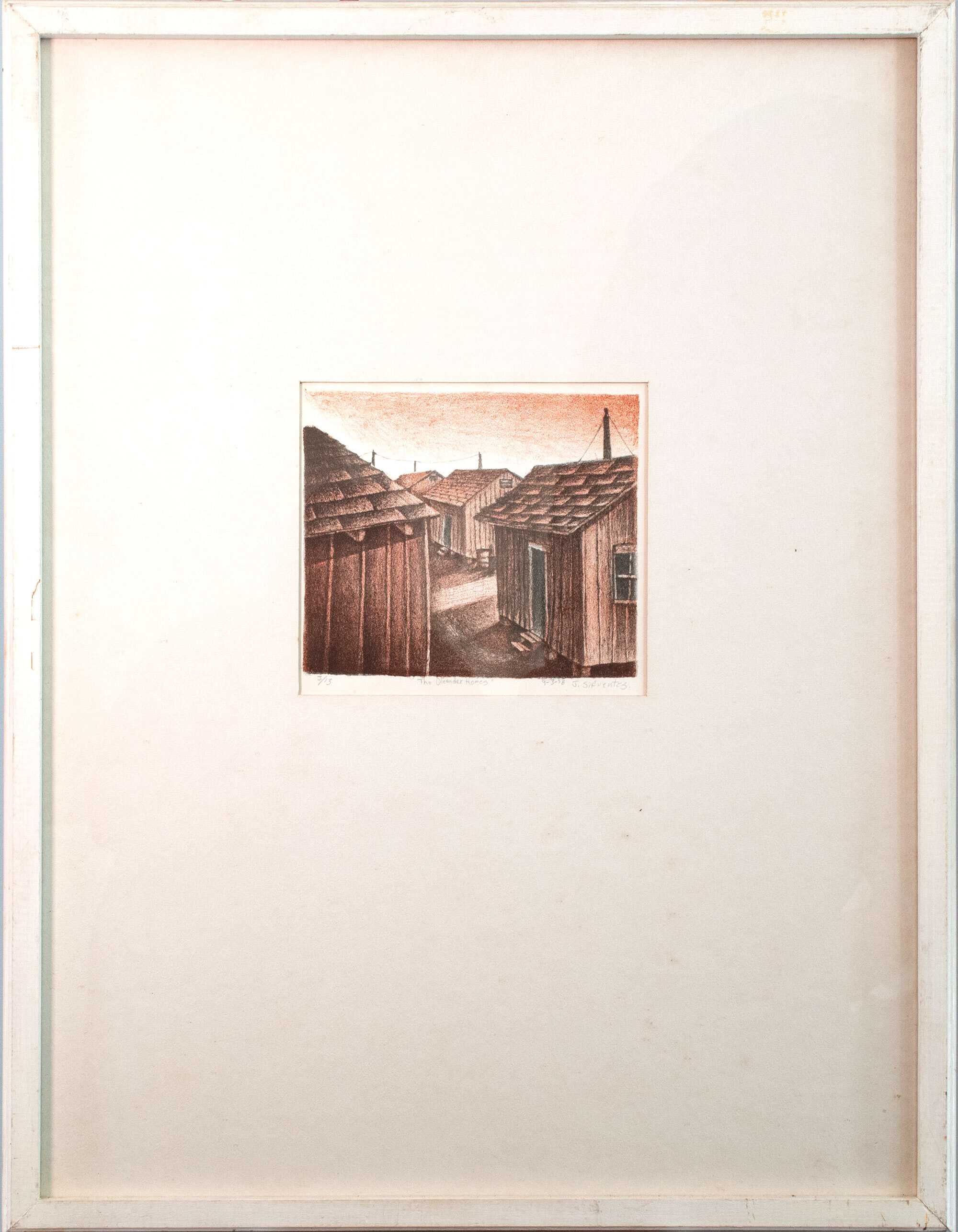A drawing of small buildings in a matte frame.