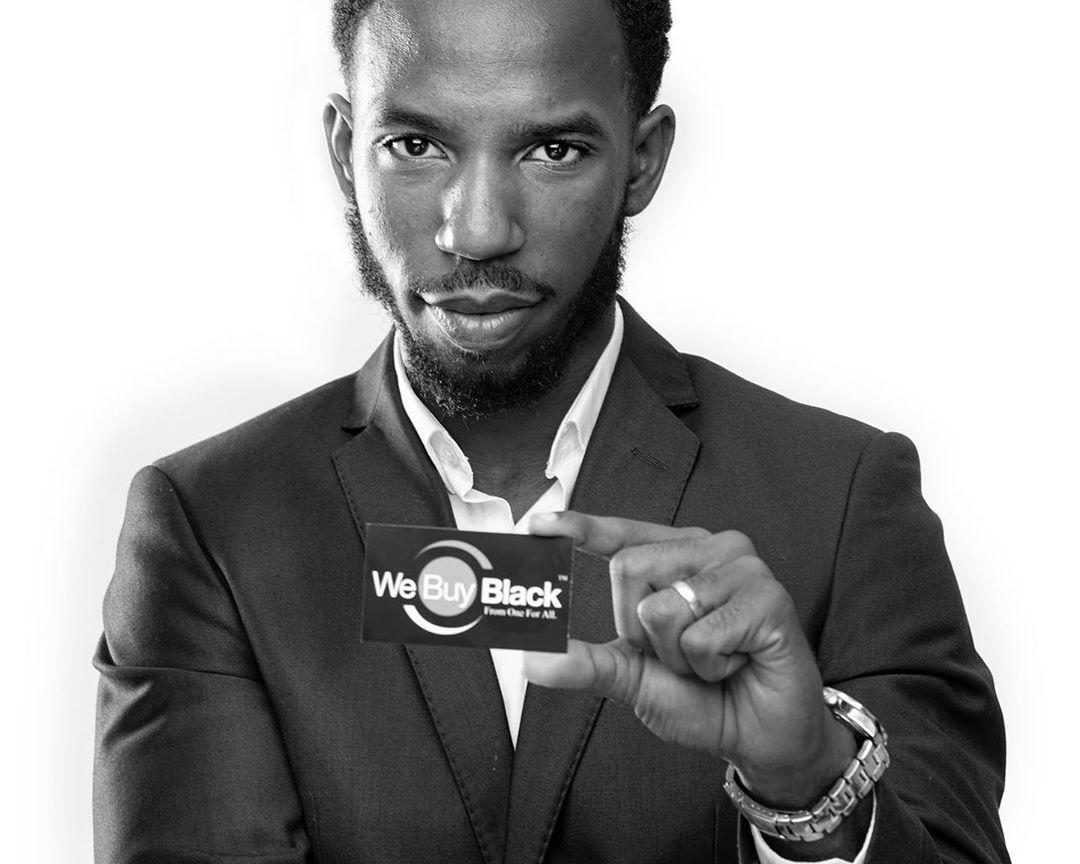 Photograph of founder with "We Buy Black" business card