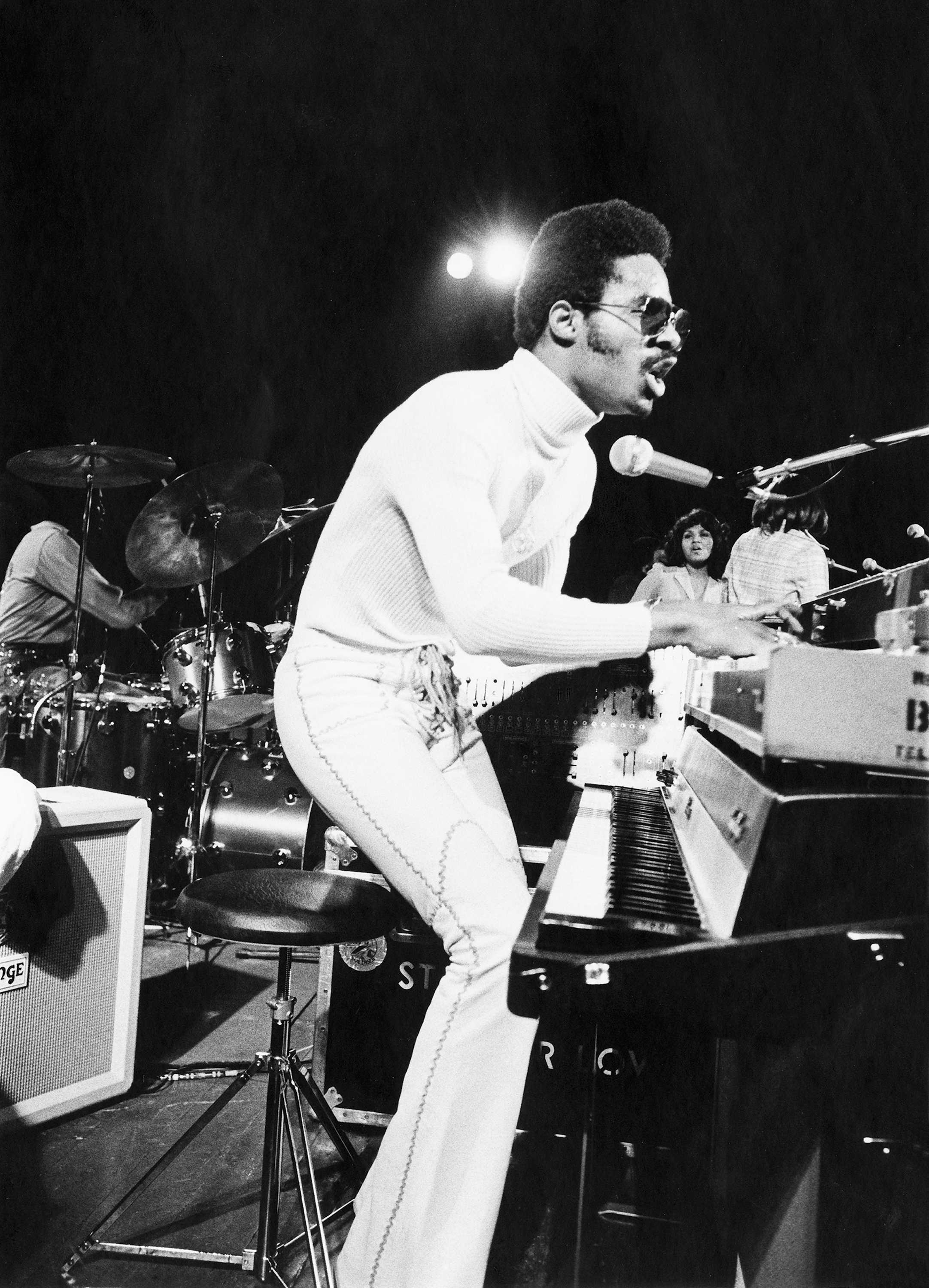 Black and white photograph of Stevie Wonder performing on stage