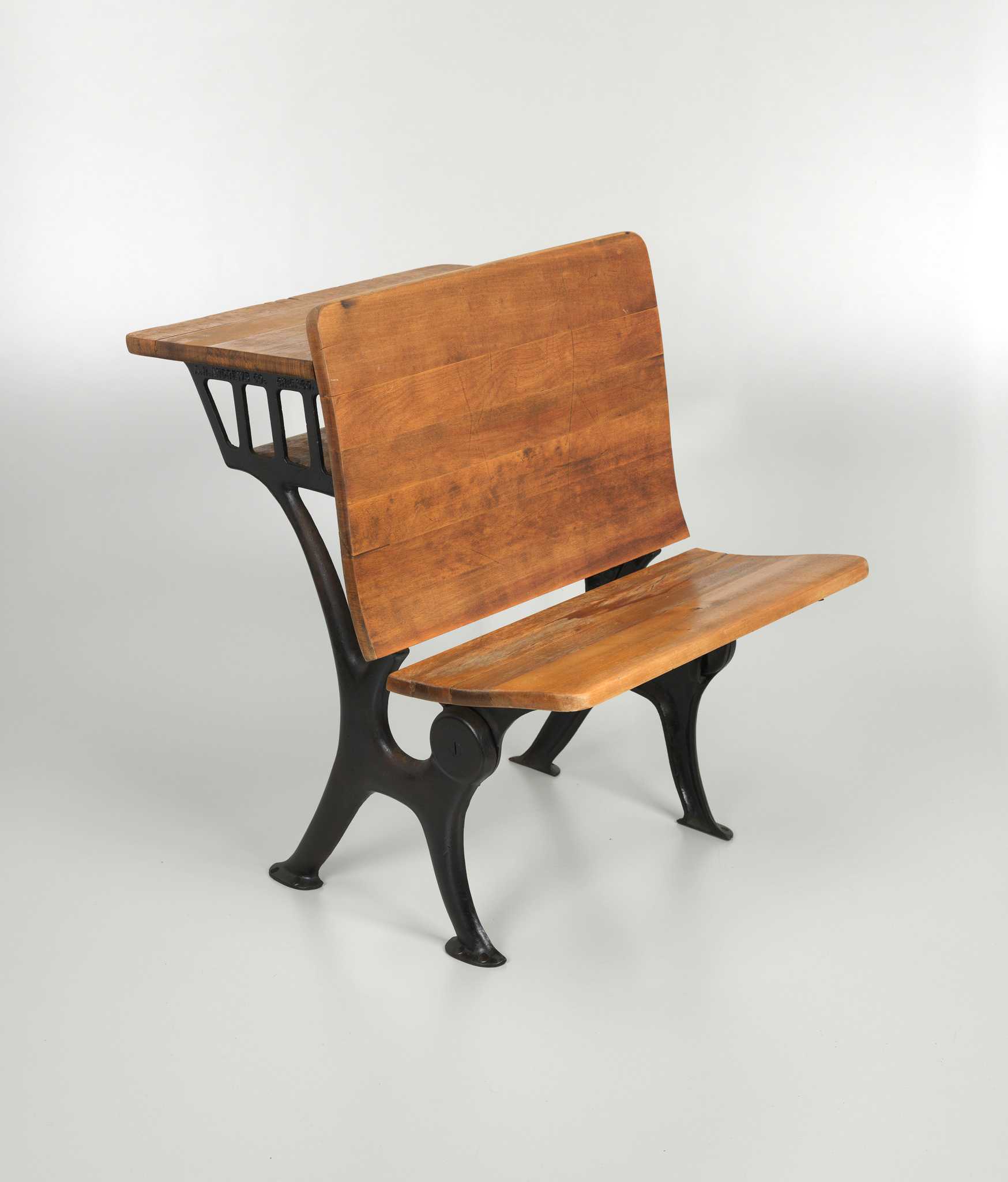 A set of ten desks from the Hope School in Pomaria, South Carolina, a historic Rosenwald school. The desks are of the "Triumph" model made by A. H. Andrews & Co. in Chicago, Illinois and are made of iron and hardwood. The back of each desk provides the writing surface for the desk behind.