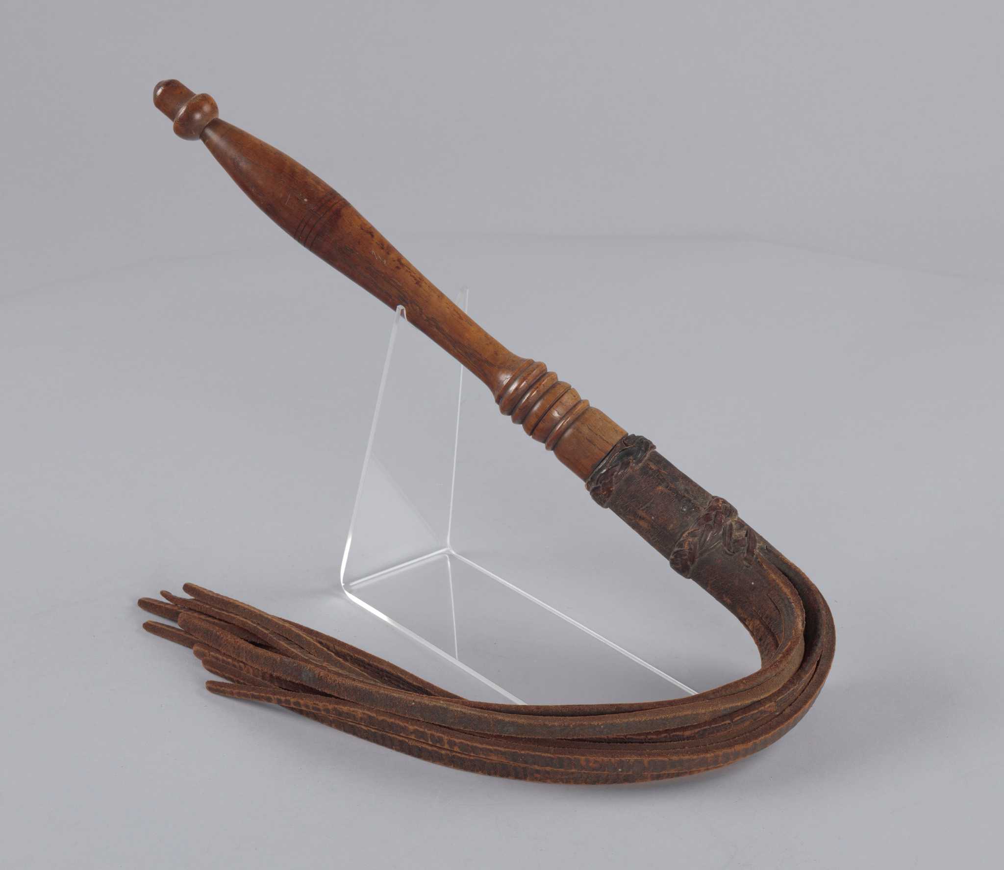 Photograph of wooden and leather whip