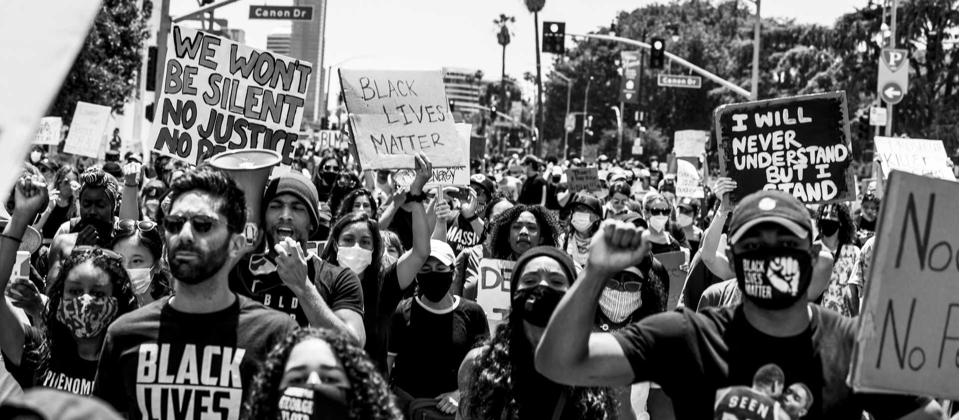 A digital, black-and-white image of Nev Schulman and Kendrick Sampson with a crowd of protesters in a Black Lives Matter protest in Beverly Hills, California, June 6, 2020.