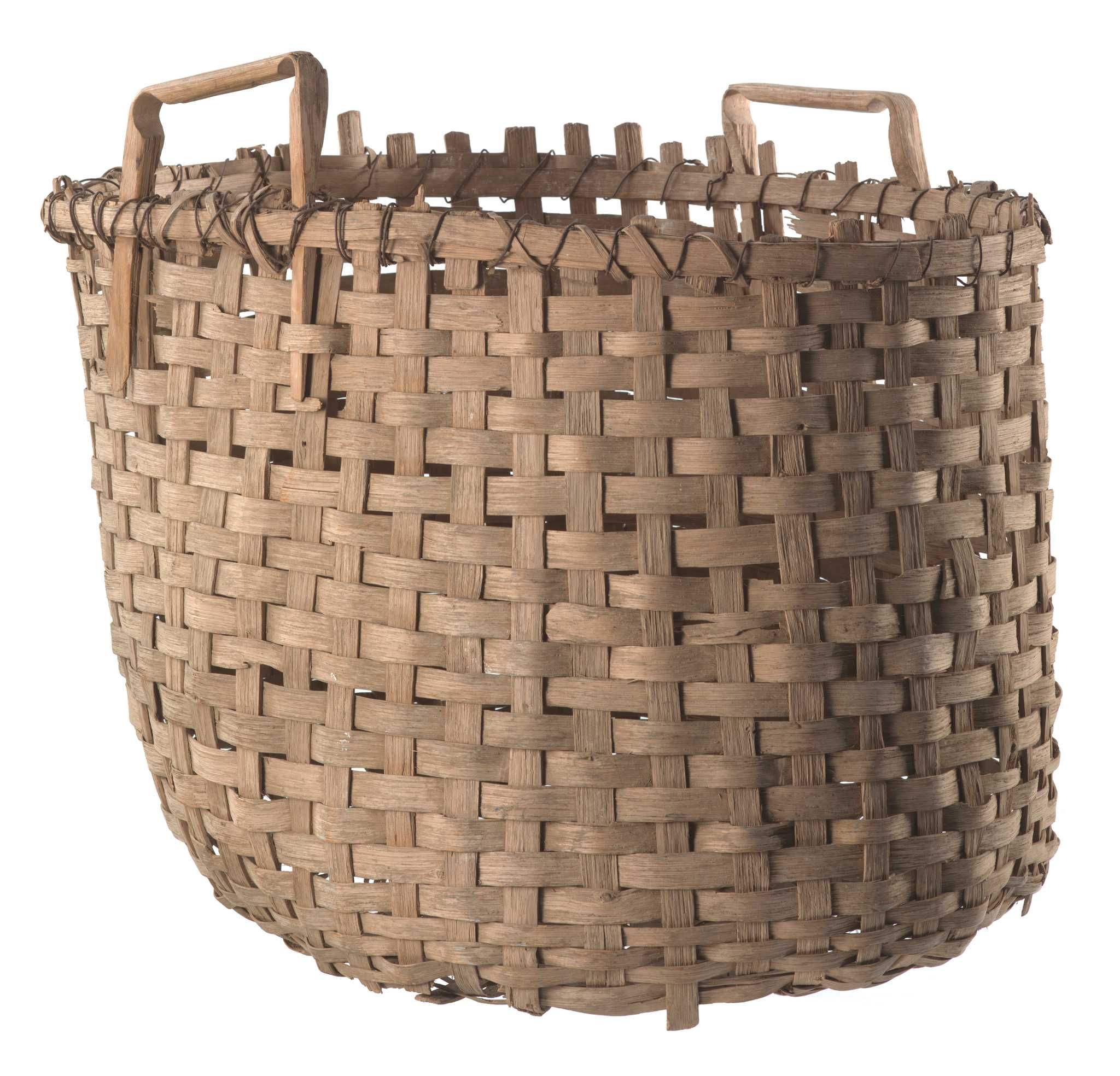 A large, woven, wooden basket for carrying cotton. This basket has been constructed using a basic under-and-over-weaving pattern with flat, wide basket strands made from strips of medium toned wood. Throughout the body of the basket, weavers and spokes vary between approximately .75” and 1” in width. At the bottom of the basket, the weavers become increasingly narrow towards the center of the base, ranging from approximately .3” to .5” in width.  The basket is roughly circular in shape, with two basket strands on the exterior and one on the interior securing the rim with wrapped metal wire. The basket has two, square, wooden handles, notched and bent at each corner and held in place by the weave of the basket body and metal wire, which has been double-wrapped in some places to provide additional support to the handles.