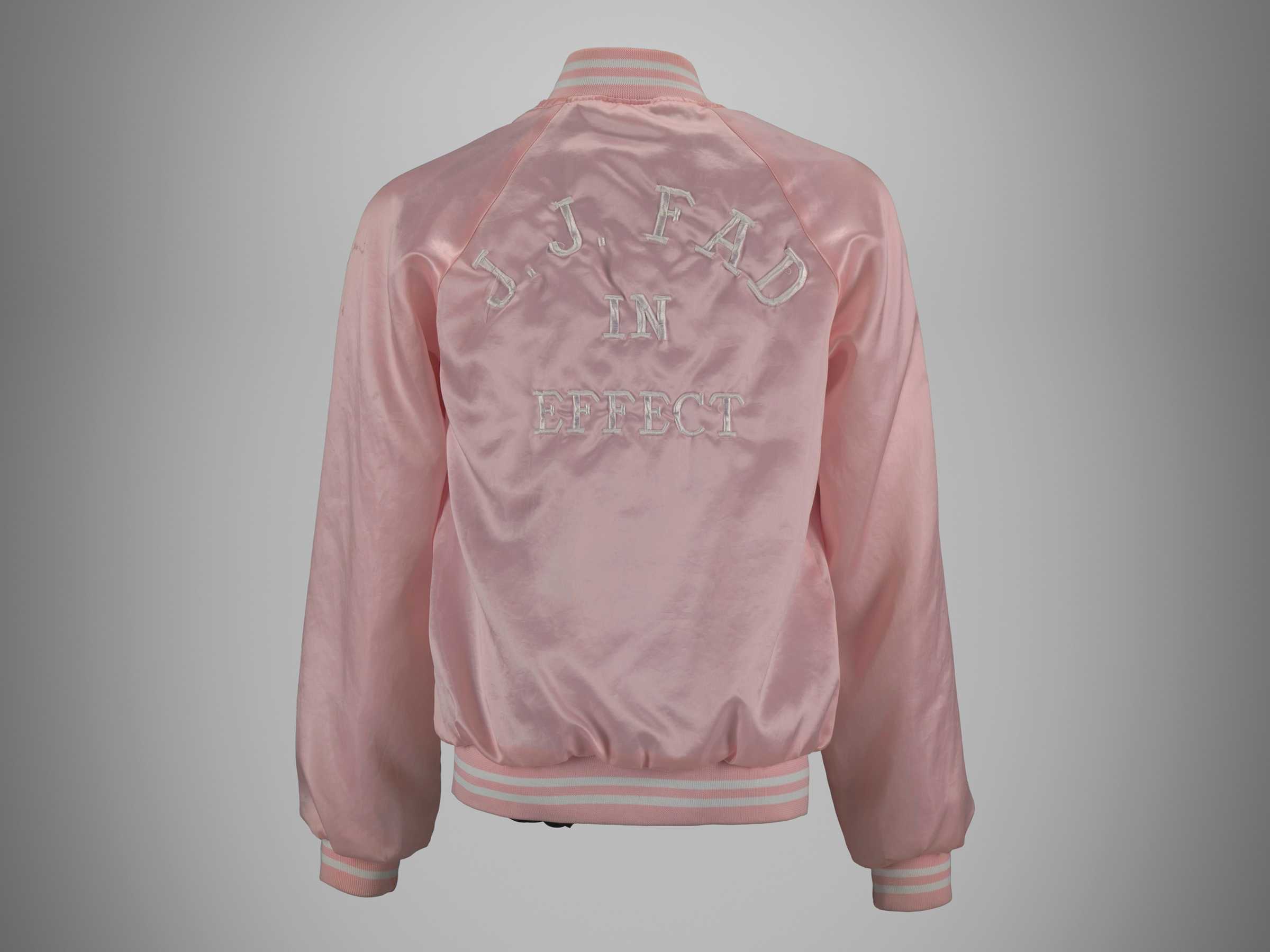 Back view of a pink satin jacket, embroidered with "J.J. Fad in Effect"