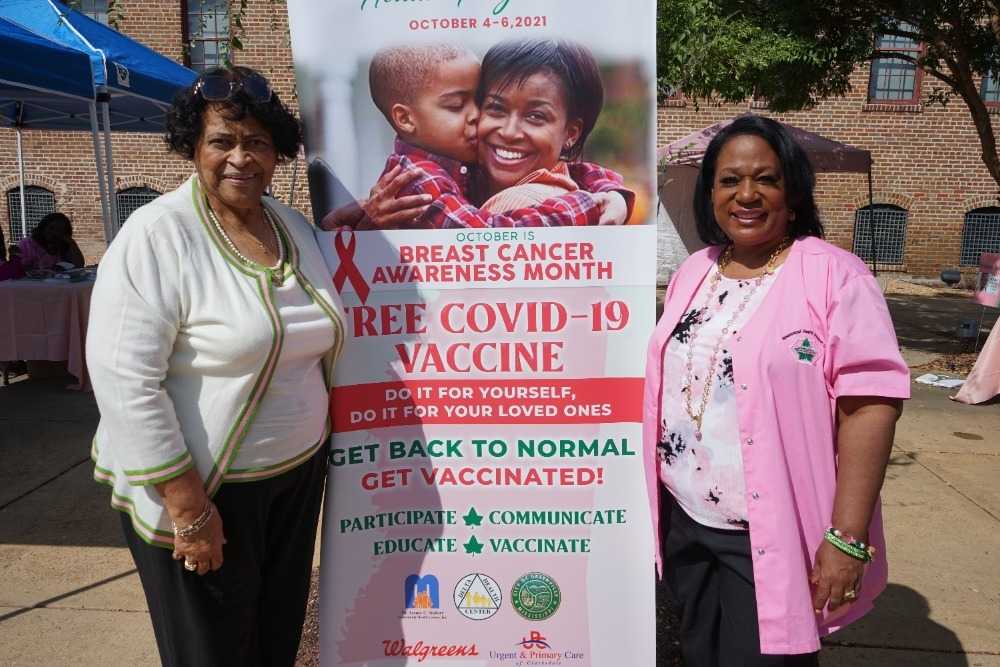 Image of women holding a poster promoting free COVID vaccines