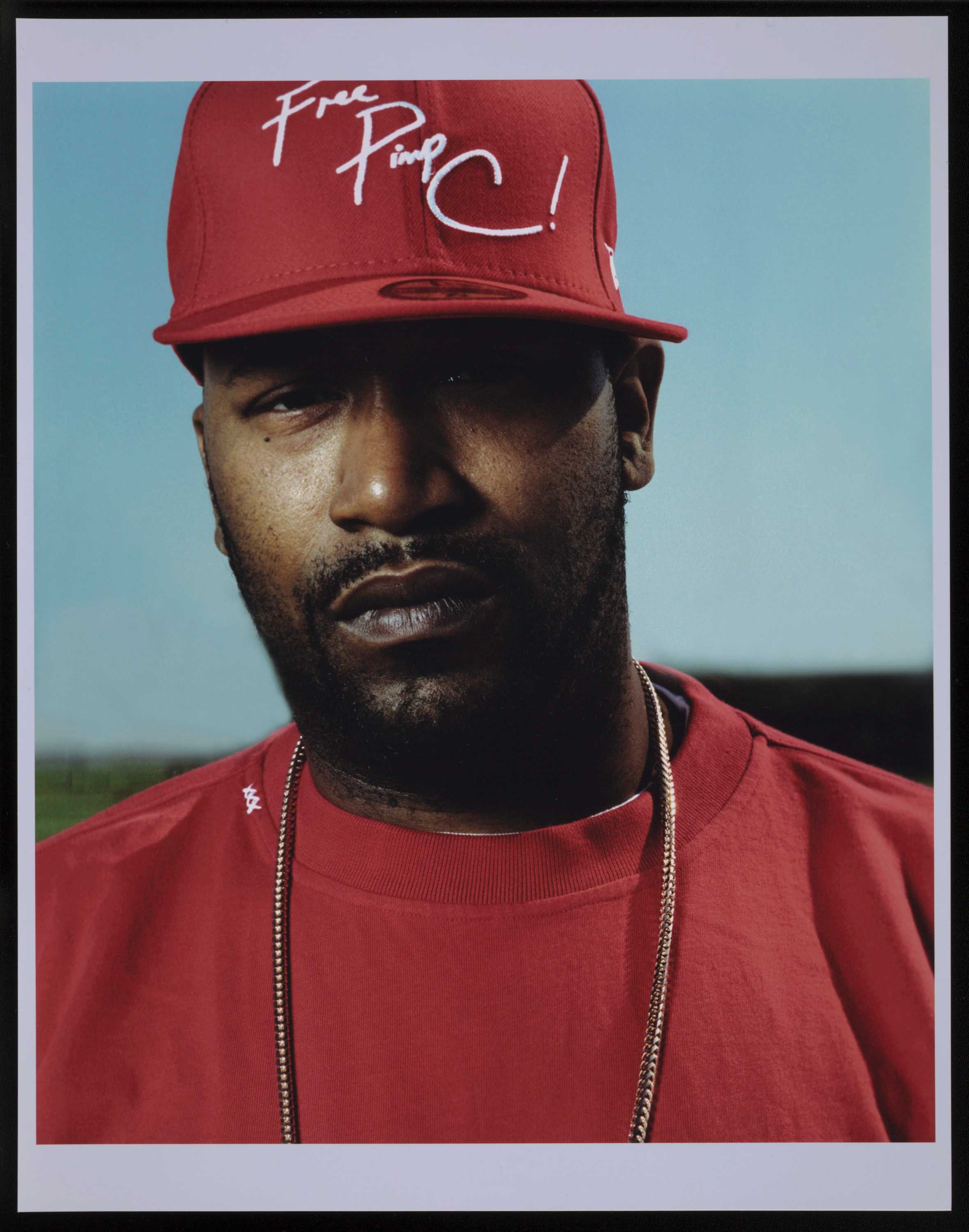 Headshot of man wearing red shirt and baseball cap