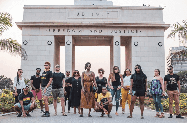 A group people pose together in front of the Independence Arch.